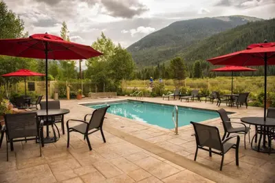 a pool with tables and chairs and red umbrellas at Red Hawk Lodge 2286 in Dillon