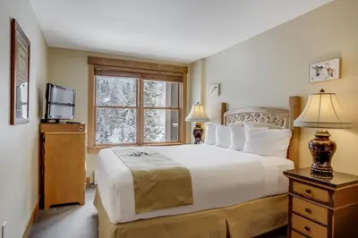 a bedroom with a large white bed and a window at Springs 8860 in Keystone
