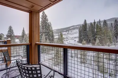 a balcony with two chairs and a view of a mountain at Springs 8860 in Keystone