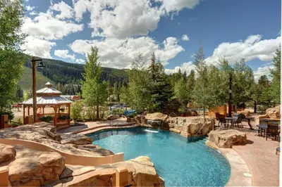 a pool in a backyard with rocks and a gazebo at Springs 8860 in Keystone