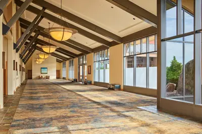 an empty hallway in a building with large windows at The Westin Westminster in Westminster