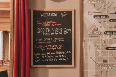 a chalk board with a menu on a wall at Ember Hostel in Denver