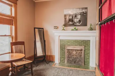 a living room with a green brick fireplace at Ember Hostel in Denver