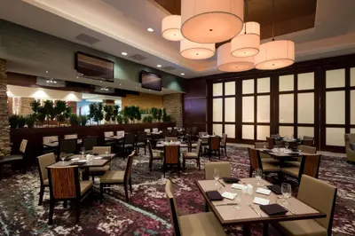 a restaurant with tables and chairs in a room at Embassy Suites by Hilton Denver Downtown Convention Center in Denver