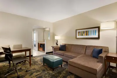 a living room with a couch and a desk at Embassy Suites by Hilton Denver Downtown Convention Center in Denver