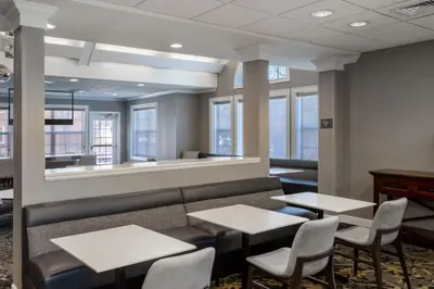a waiting room with tables and chairs and windows at Residence Inn by Marriott Boulder Broomfield in Louisville