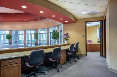 an office with a long bar with chairs in front of it at Embassy Suites Loveland Conference Center in Loveland