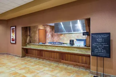 a restaurant counter with a sign in a room at Embassy Suites Loveland Conference Center in Loveland