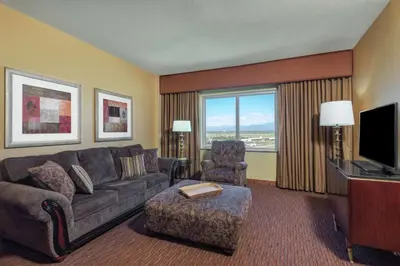 a living room with a couch and a chair and a television at Embassy Suites Loveland Conference Center in Loveland