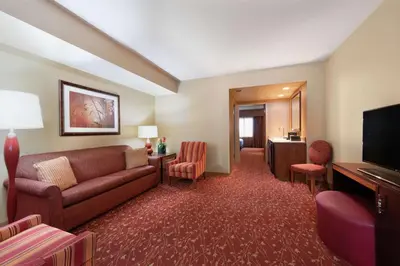 a hotel room with a couch and a television at Embassy Suites Loveland Conference Center in Loveland