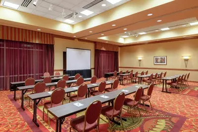 a conference room with tables and chairs and a whiteboard at Embassy Suites Loveland Conference Center in Loveland