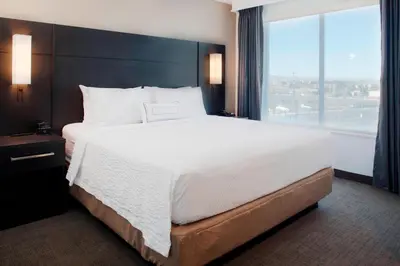 a large bed in a hotel room with a large window at Residence Inn by Marriott Boulder Broomfield/Interlocken in Broomfield