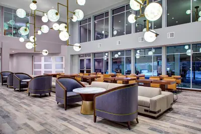a lobby with tables and chairs and chandeliers at Fairfield by Marriott Inn and Suites Boulder Broomfield Interlocken in Broomfield