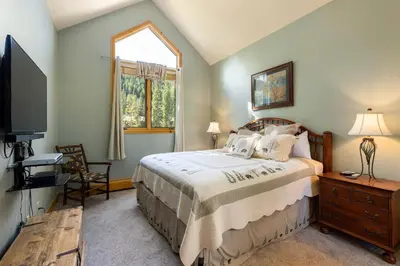 a bedroom with a bed and a tv and a window at 2985 Ironwood Townhomes in Keystone