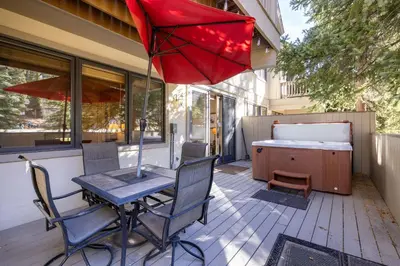 a patio with a table and chairs and an umbrella at 2985 Ironwood Townhomes in Keystone