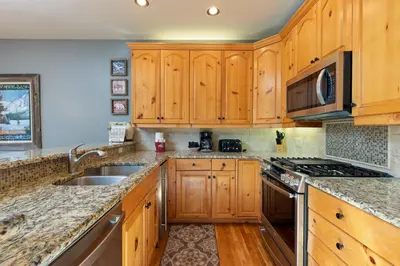 a kitchen with wooden cabinets and a sink at 2985 Ironwood Townhomes in Keystone