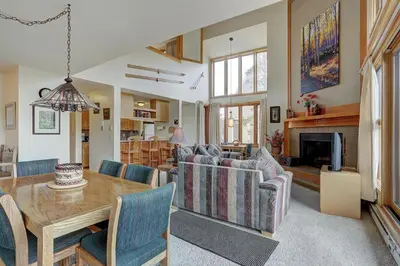 a living room with a table and chairs and a fireplace at 2072 The Pines Condo in Keystone