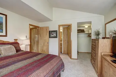 a bedroom with a bed and a dresser and a television at 2072 The Pines Condo in Keystone