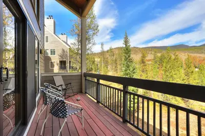 a balcony with two benches and a view of the mountains at 2072 The Pines Condo in Keystone