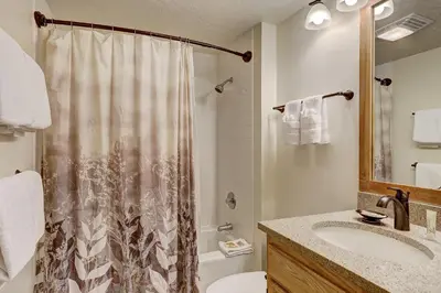 a bathroom with a shower and a toilet and a sink at 2072 The Pines Condo in Keystone