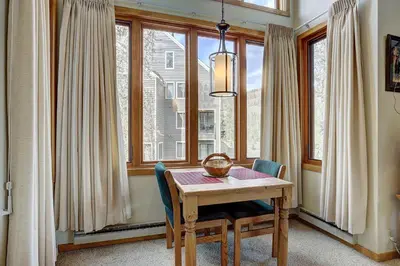 a dining room with a table and some windows at 2072 The Pines Condo in Keystone