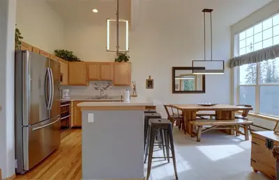 a kitchen with a refrigerator and a table with chairs at A5 Gore Trail Condo in Silverthorne
