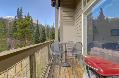 a balcony with a table and two stools on it at A5 Gore Trail Condo in Silverthorne
