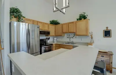 a kitchen with a stainless steel refrigerator and wooden cabinets at A5 Gore Trail Condo in Silverthorne