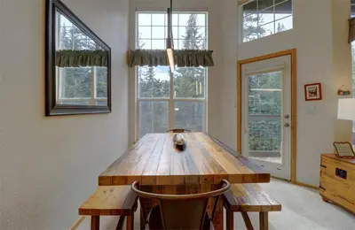 a large wooden table in a room with windows at A5 Gore Trail Condo in Silverthorne