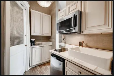 a kitchen with a sink and a microwave at The Holiday Chalet Victorian in Denver