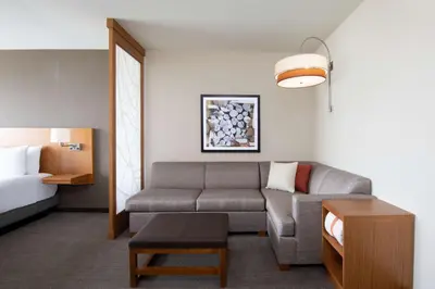 a living room with a couch and a bed at Hyatt Place Westminster Denver in Westminster