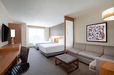 a hotel room with a bed and a couch at Hyatt Place Westminster Denver in Westminster