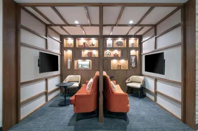 a waiting room with an orange couch and tv at Hyatt Place Westminster Denver in Westminster