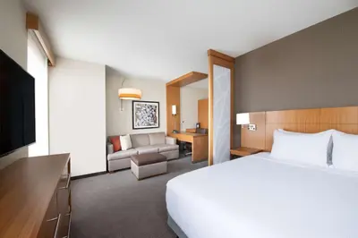 a hotel room with a bed and a living room at Hyatt Place Westminster Denver in Westminster