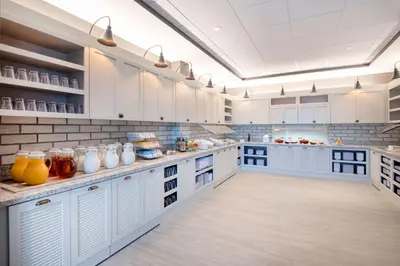 a large kitchen with white cabinets and blue counters at Hyatt Place Westminster Denver in Westminster