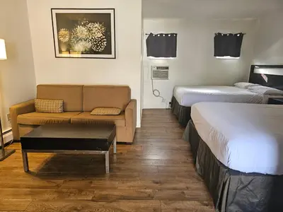 a hotel room with two beds and a couch at H&H Motor Lodge in Idaho Springs