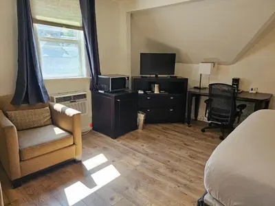 a bedroom with a bed and a desk and a television at H&H Motor Lodge in Idaho Springs