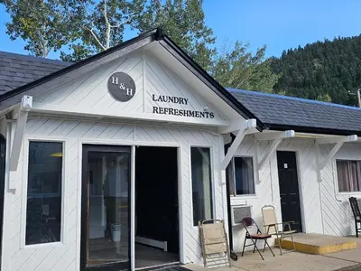 a white building with a sign that reads laundry requirements at H&H Motor Lodge in Idaho Springs