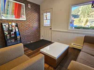 a waiting room with a coffee table and a window at H&H Motor Lodge in Idaho Springs