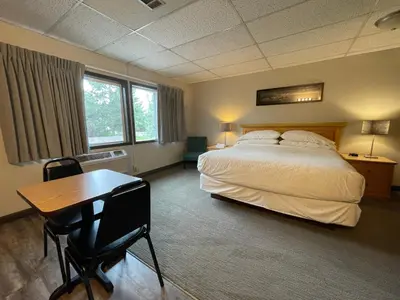 a bedroom with a bed and a desk and a table at Boulder Twin Lakes Inn in Boulder