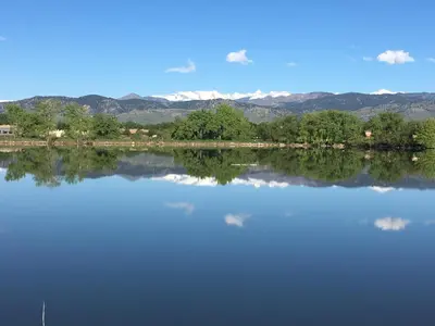 a large lake with trees and mountains in the background at Boulder Twin Lakes Inn in Boulder