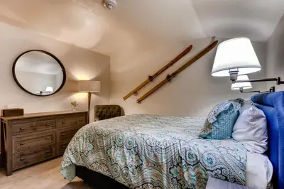 a bedroom with a bed and a mirror and a dresser at Ski Tip Lodge, A Vail Resorts Property in Keystone