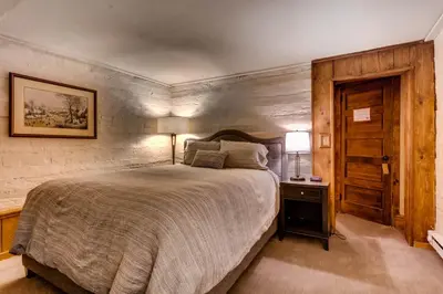 a bedroom with a large bed and a wooden door at Ski Tip Lodge, A Vail Resorts Property in Keystone