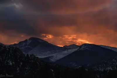 a fire in the sky over the mountains at Gateway to the Wildside Townhouse in Estes Park