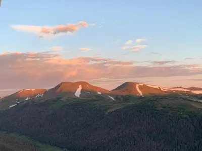 a view of a mountain with trees and a sunset at Gateway to the Wildside Townhouse in Estes Park