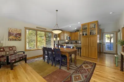 a kitchen and dining room with a table and chairs at Gateway to the Wildside Townhouse in Estes Park