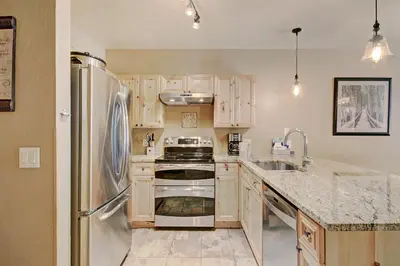 a kitchen with white cabinets and a stainless steel refrigerator at 2609 Tenderfoot Lodge Condo in Keystone