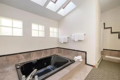 a large bathroom with a tub and a sink at Boulder Brook on Fall River in Estes Park
