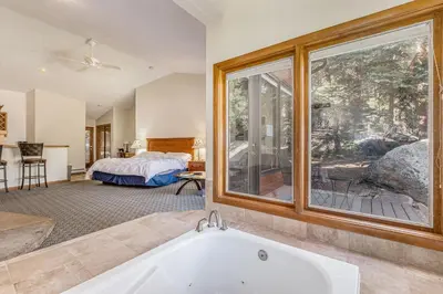 a bath tub in a room with a bedroom at Boulder Brook on Fall River in Estes Park