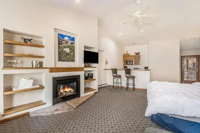 a bedroom with a bed and a fireplace at Boulder Brook on Fall River in Estes Park